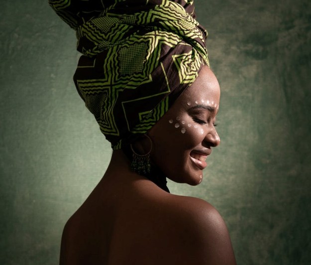 smiling woman wearing green and black turban